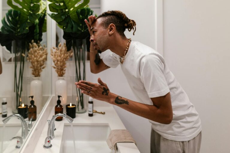 A guy in the bathroom practicing the new grooming tips he learned